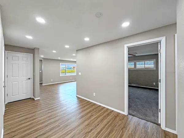 a view of an empty room with wooden floor and closet
