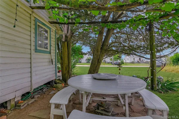 a view of a table and chairs in backyard of the house