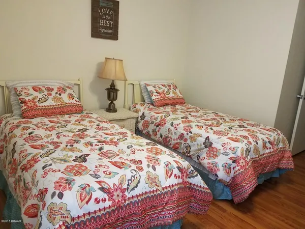 a bedroom with two beds and a lamp