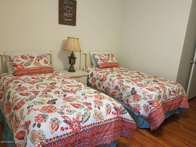 a bedroom with two beds and a lamp