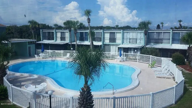 a view of a swimming pool with a patio and a yard
