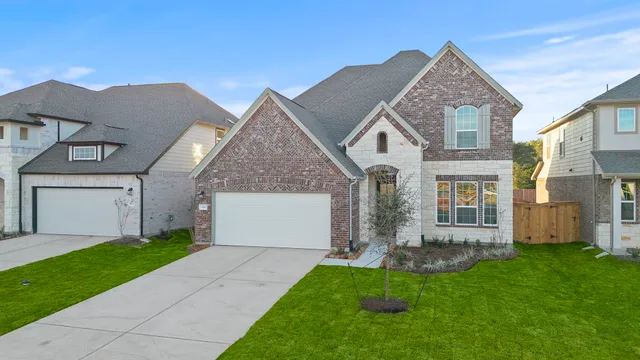 a front view of a house with a garden and yard