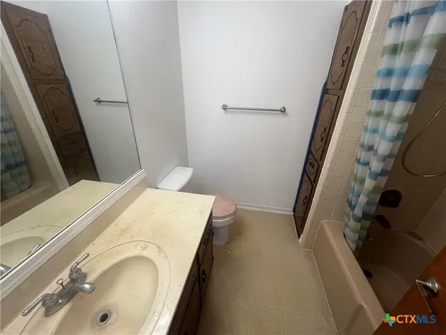 a bathroom with a granite countertop toilet and a sink