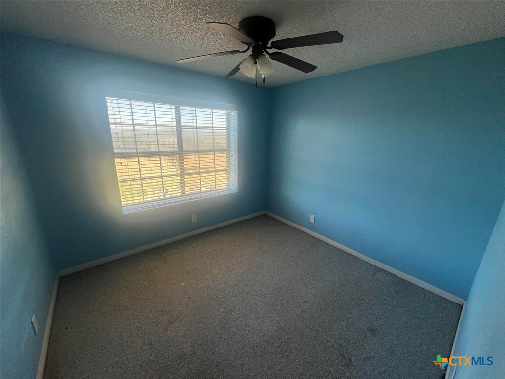 20239 Stillman Valley Road Florence, TX 76527 - Photo 19 of 35 an empty room with a window and a fan