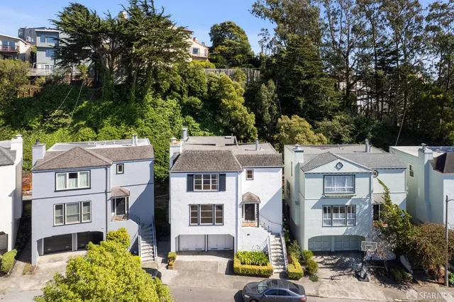 an aerial view of a residential apartment building with a yard and parking space