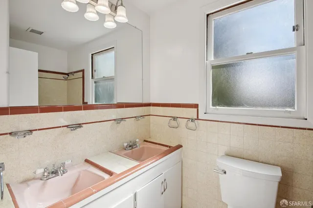 a bathroom with a sink toilet and window