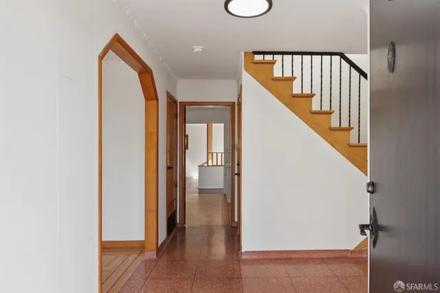 a view of a hallway with wooden floor and staircase
