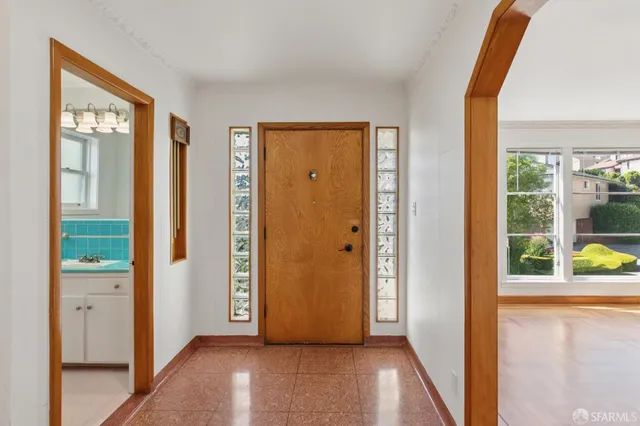 a view of a hallway with wooden floor and windows