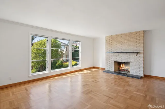 a view of an empty room with a fireplace and a window