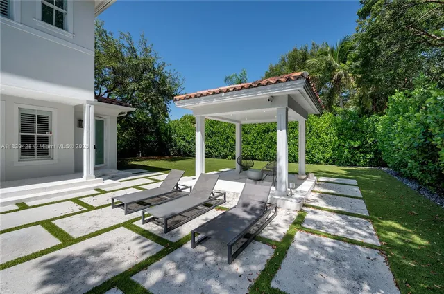 a view of a patio with table and chairs under an umbrella