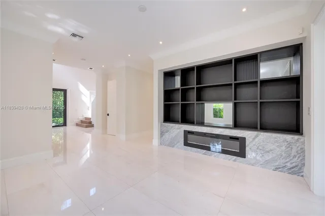 a view of a hallway with wooden floor and a living room