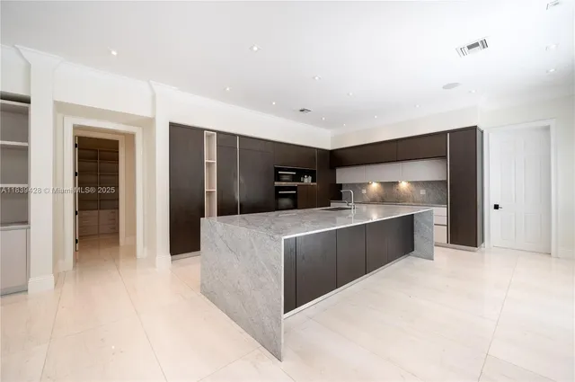 a bathroom with a granite countertop sink and white cabinets