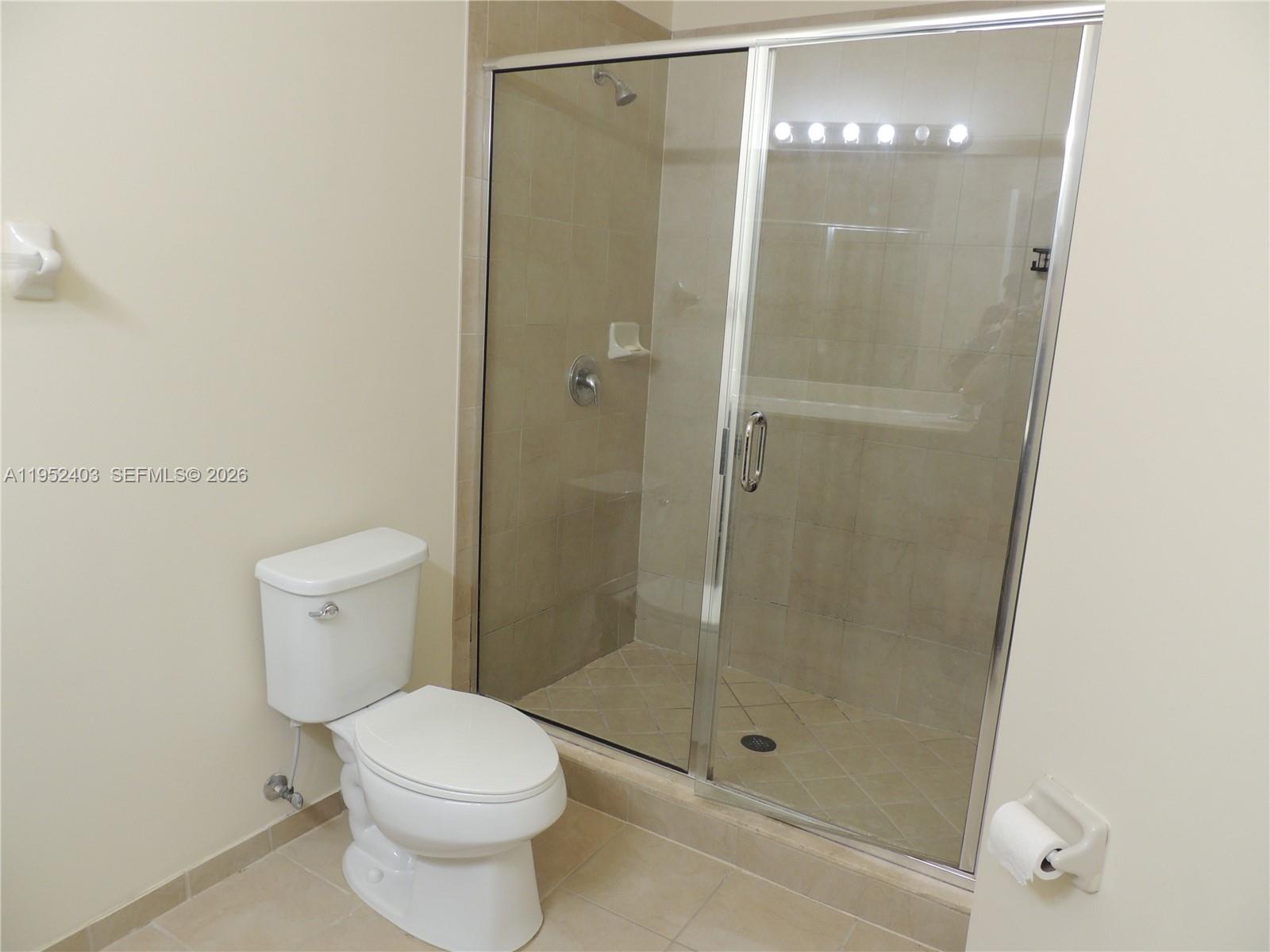 3344 West 91st Terrace, Unit 3344 Hialeah, FL 33018 - Photo 16 of 22 a bathroom with a shower and a toilet