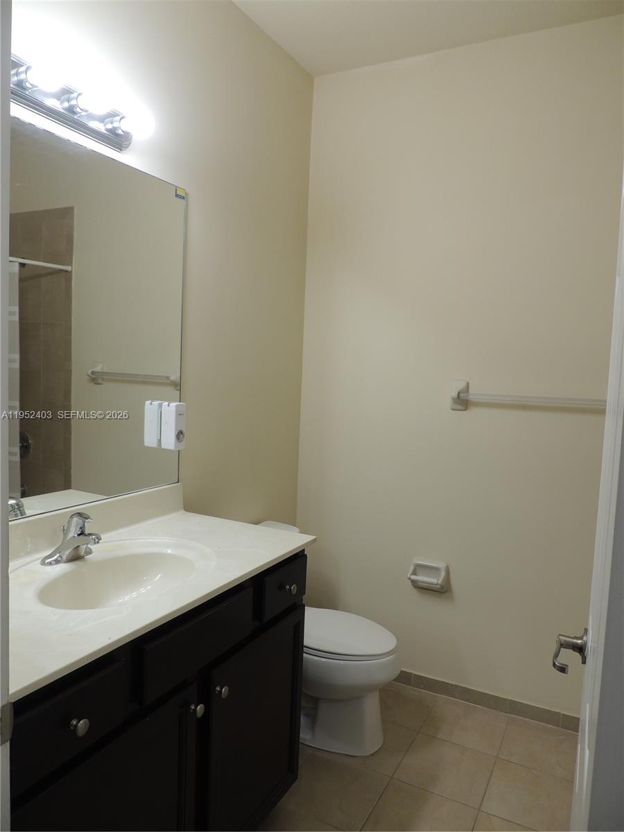 3344 West 91st Terrace, Unit 3344 Hialeah, FL 33018 - Photo 19 of 22 a bathroom with a sink a toilet and mirror