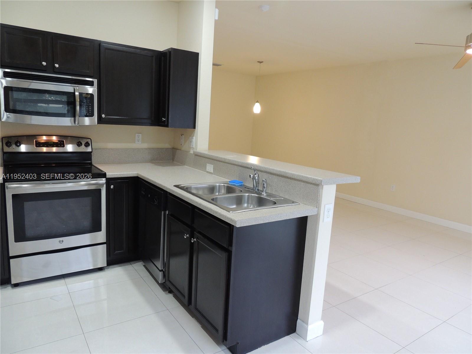 3344 West 91st Terrace, Unit 3344 Hialeah, FL 33018 - Photo 10 of 22 a kitchen with a stove and a microwave