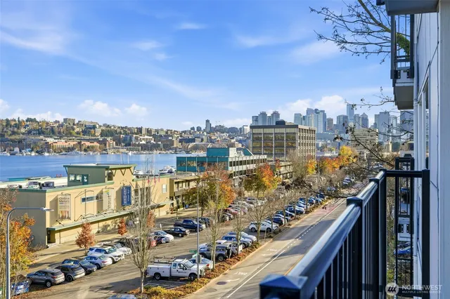 a living room with furniture a flat screen tv and a refrigerator