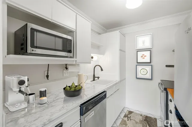 a kitchen with stainless steel appliances a refrigerator sink and white cabinets