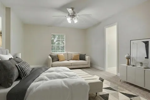a bedroom with a large bed and ceiling fan