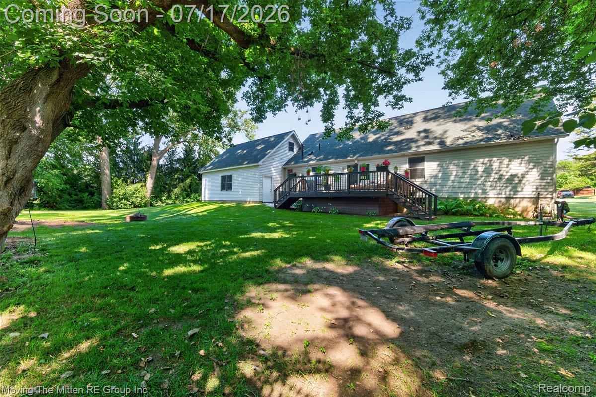 40162 Alden Road Belleville, MI 48111 - Photo 51 of 67 Expansive green lawn with mature trees and a multi-level deck featuring dark wood railings and stairs