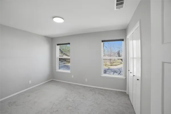 an empty room with windows and closet
