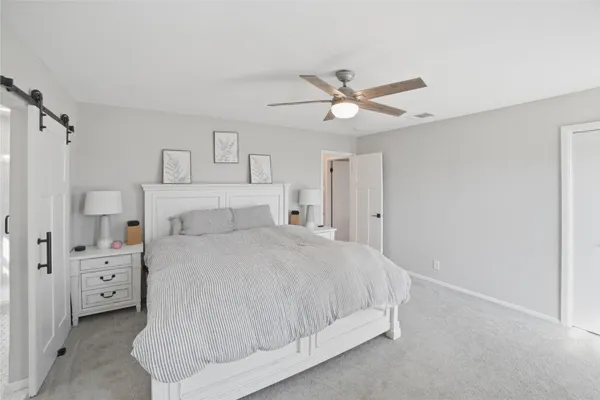 a spacious bedroom with a bed and a ceiling fan