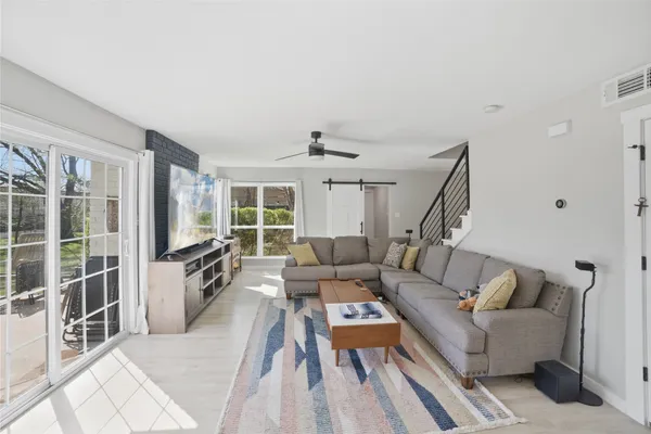 a living room with furniture a flat screen tv and a large window