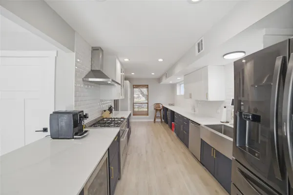 a large kitchen with a large counter top appliances and cabinets
