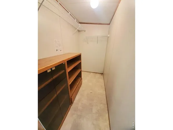 a view of walk in closet with clothes