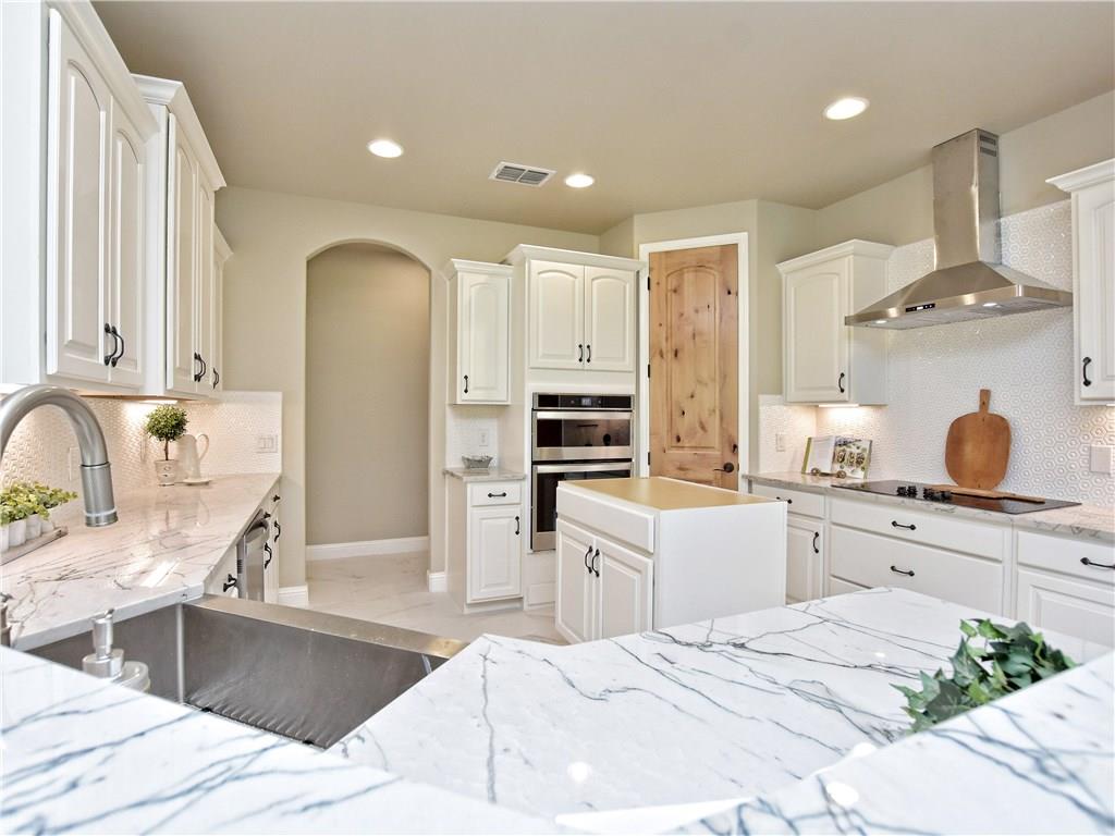 133 Tuscany Way Georgetown, TX 78633 - Photo 11 of 30 a kitchen with stainless steel appliances kitchen island granite countertop a sink and cabinets