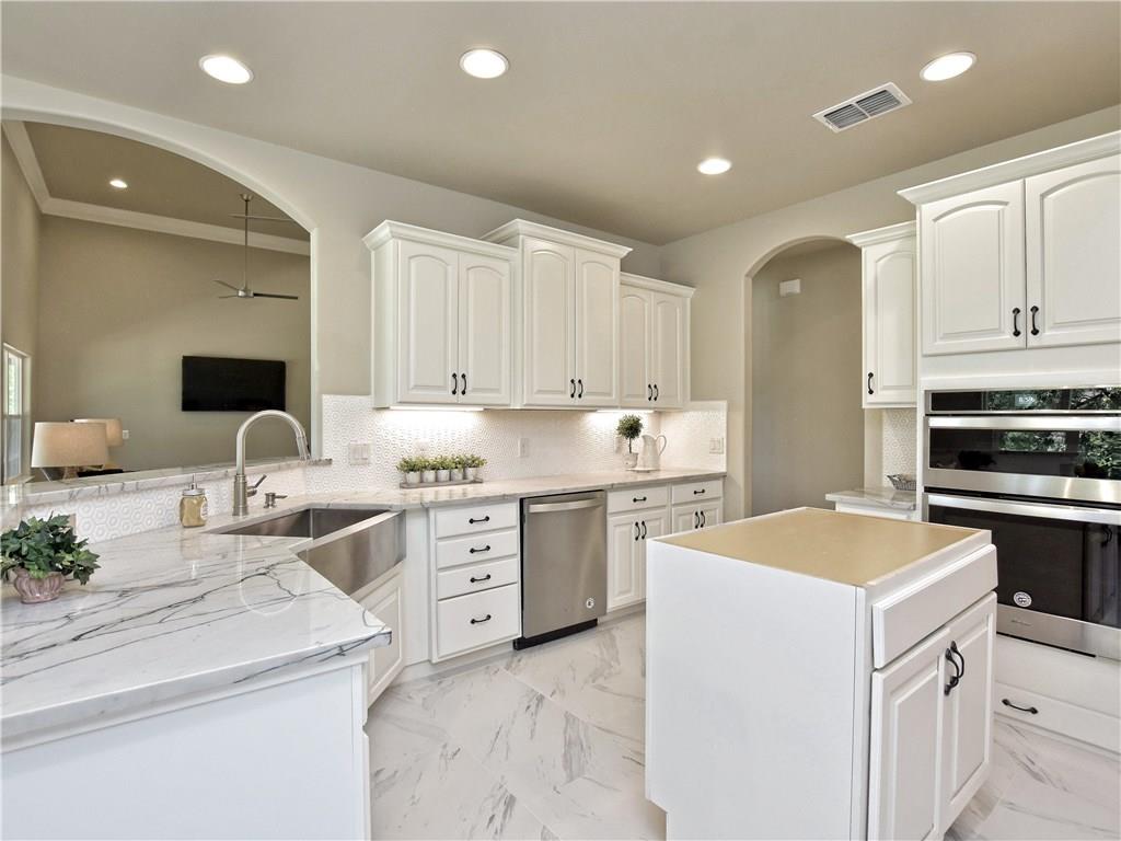 133 Tuscany Way Georgetown, TX 78633 - Photo 12 of 30 a kitchen with granite countertop white cabinets and white appliances