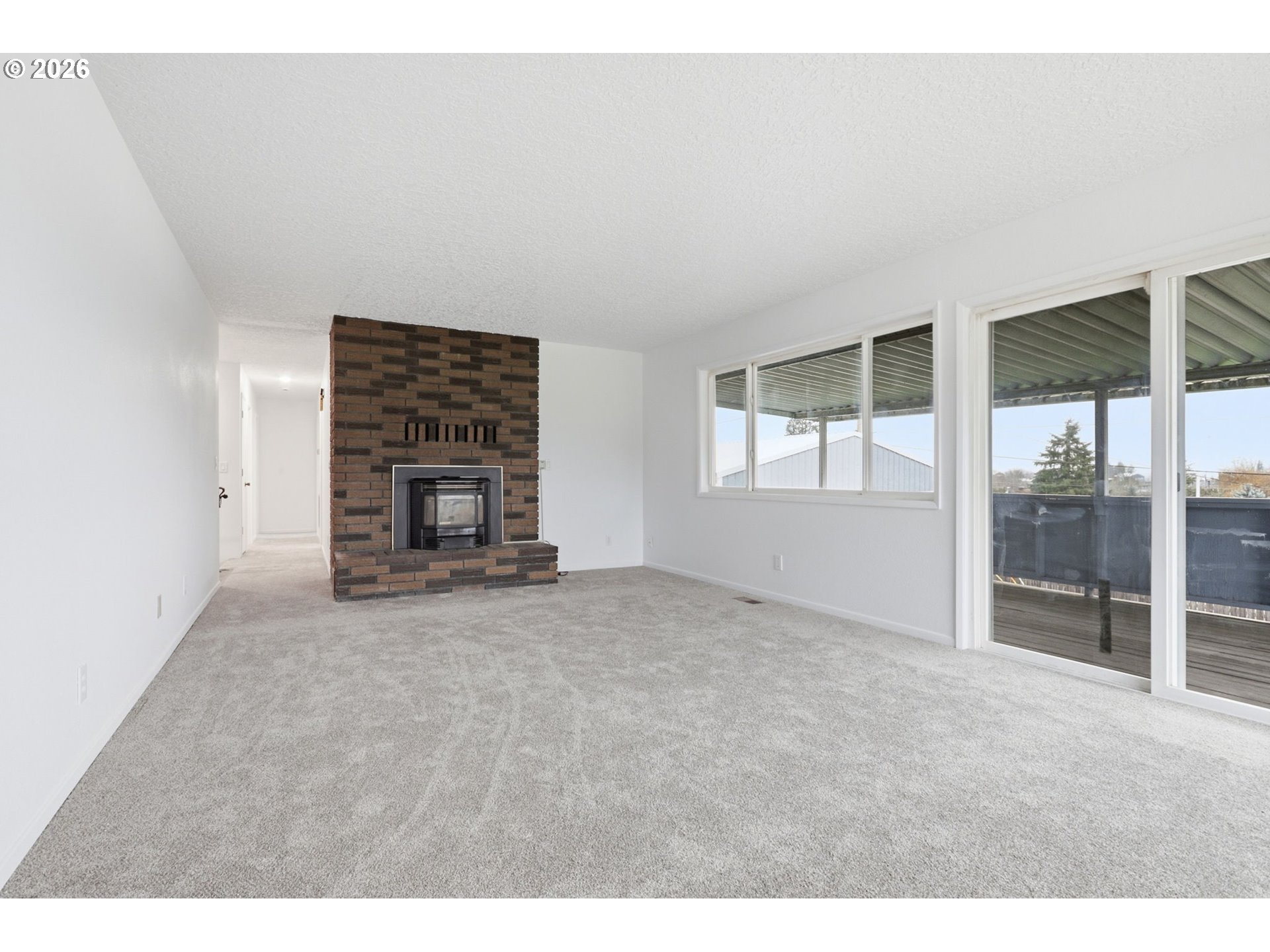 52890 Northwest 7th Street Scappoose, OR 97056 - Photo 13 of 48 a view of an empty room with fireplace and a window