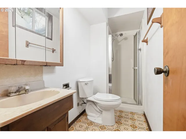 a bathroom with a sink toilet a mirror and shower