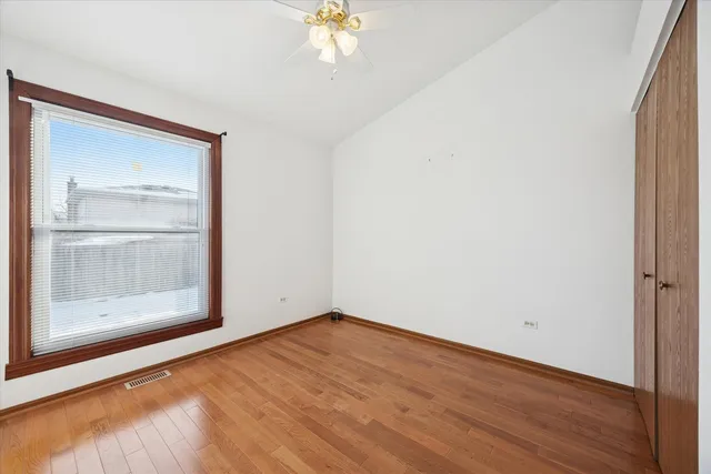 an empty room with a mirror and a hardwood floor