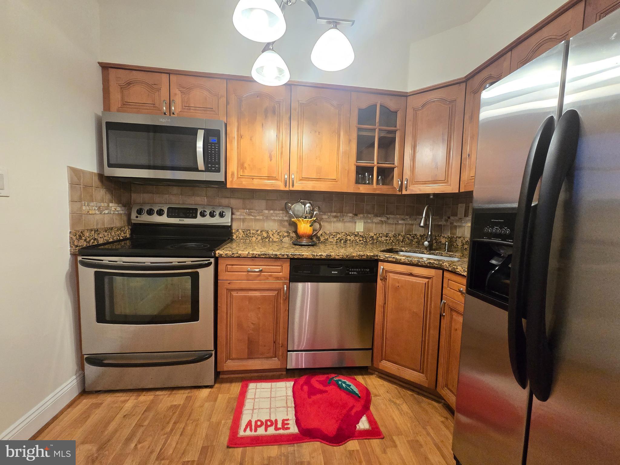 414 Kerwin Road Silver Spring, MD 20901 - Photo 6 of 14 a kitchen with granite countertop a stove a microwave a sink and a refrigerator