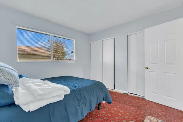 a bedroom with a bed and a painting on the wall