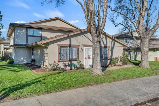 a view of a house with backyard and a tree