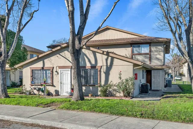 a front view of a house with a garden and plants