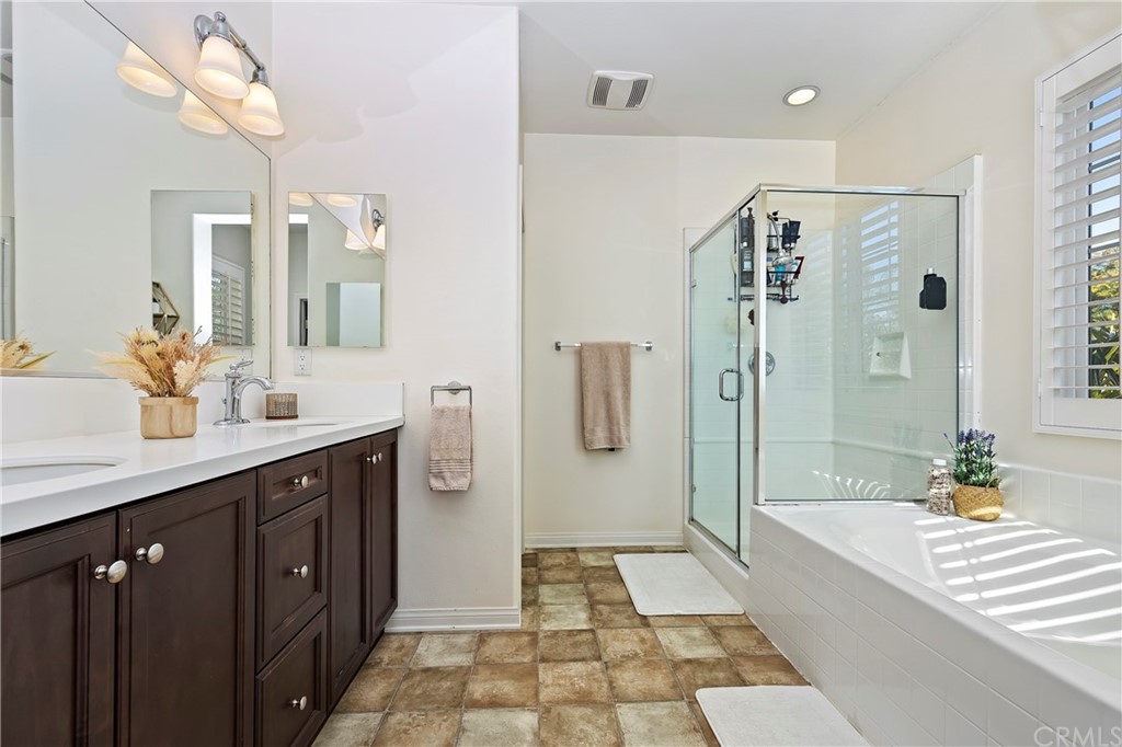6579 Eucalyptus Avenue Chino, CA 91710 - Photo 22 of 30 a spacious bathroom with a double vanity sink a large mirror and shower