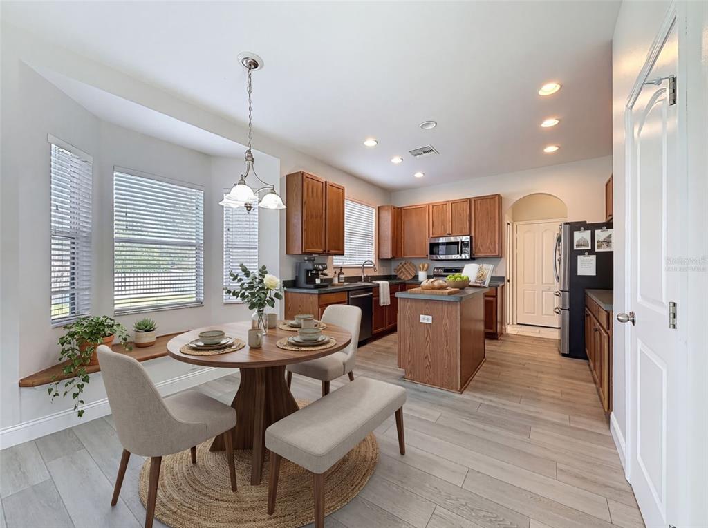 3311 Sisal Loop Wesley Chapel, FL 33544 - Photo 19 of 85 a kitchen with a dining table chairs wooden floor and appliances