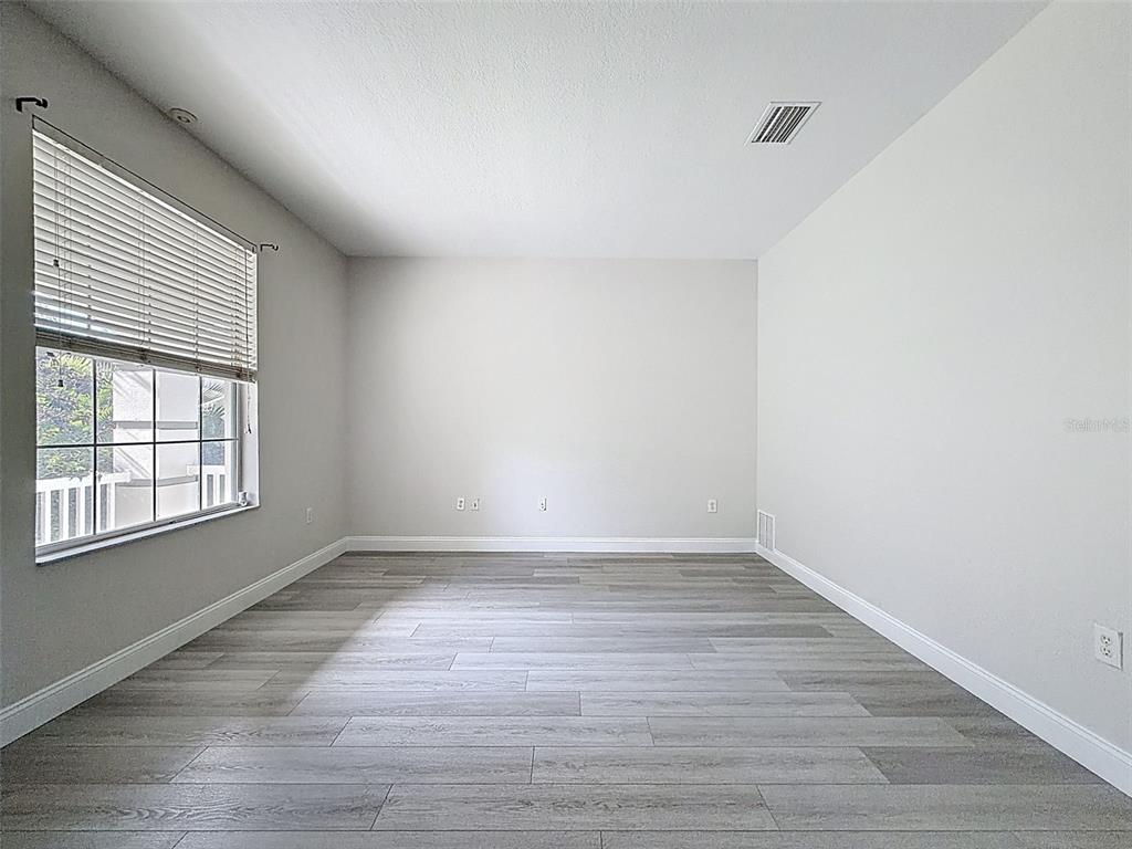 3311 Sisal Loop Wesley Chapel, FL 33544 - Photo 27 of 85 wooden floor in an empty room with a window