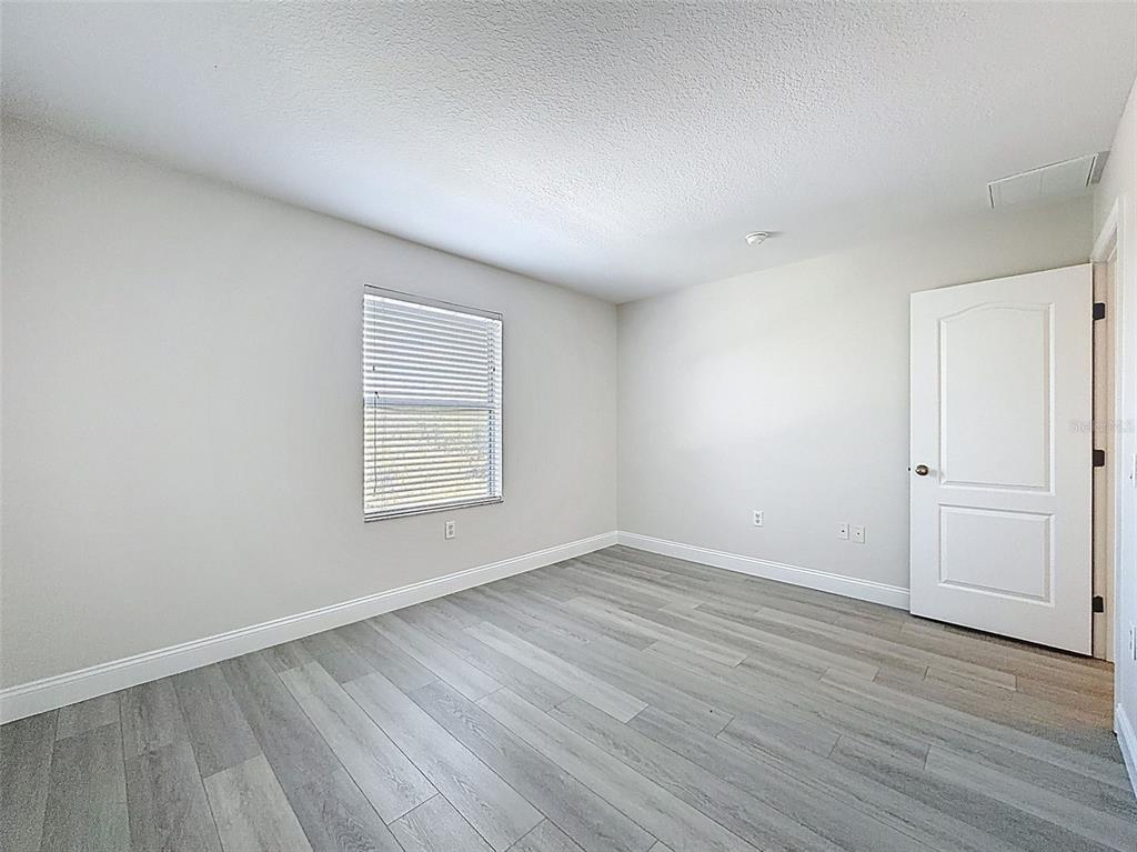 3311 Sisal Loop Wesley Chapel, FL 33544 - Photo 37 of 85 a view of an empty room with wooden floor and a window