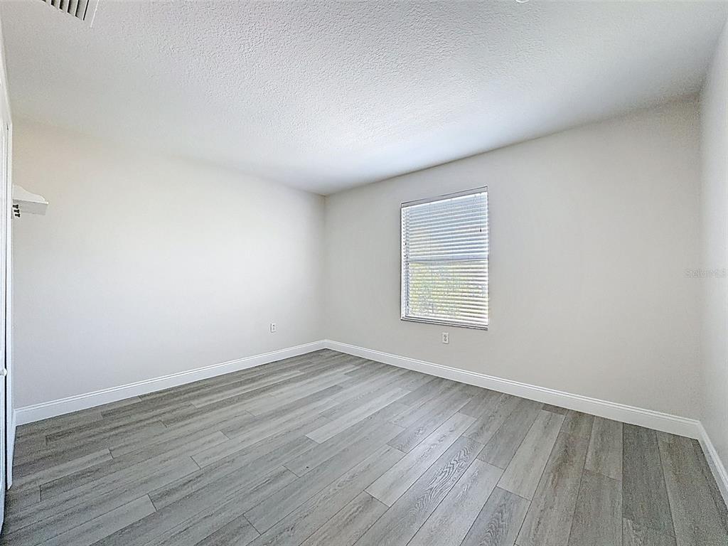 3311 Sisal Loop Wesley Chapel, FL 33544 - Photo 39 of 85 an empty room with wooden floor and windows