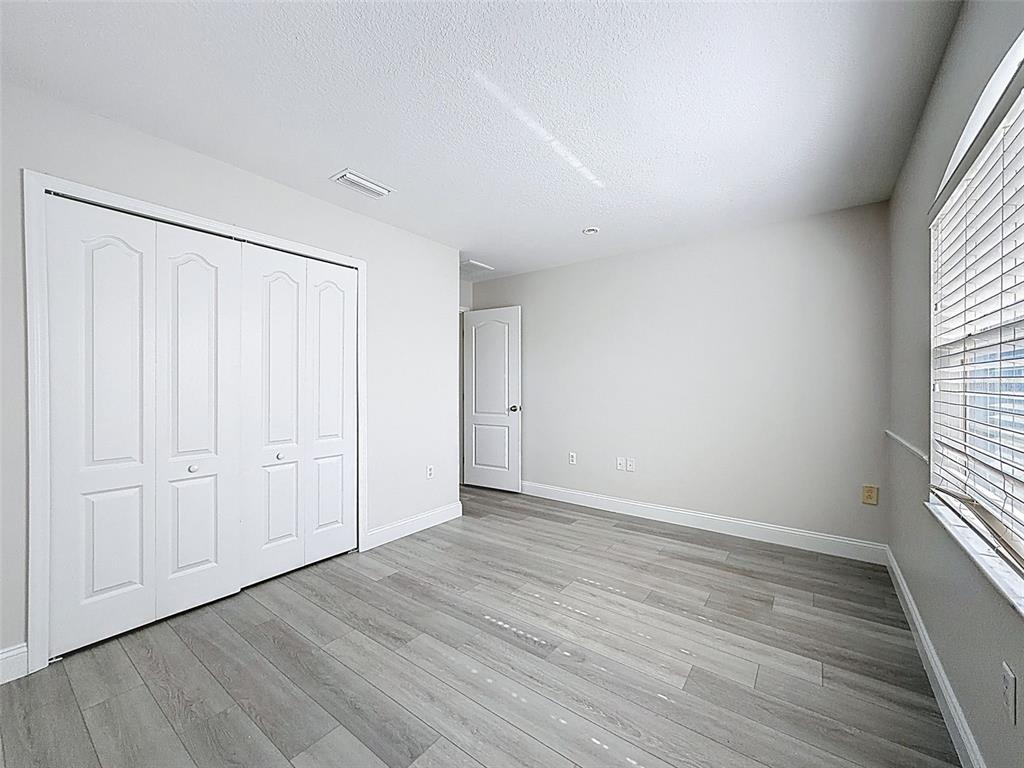 3311 Sisal Loop Wesley Chapel, FL 33544 - Photo 47 of 85 a view of an empty room with wooden floor and a window