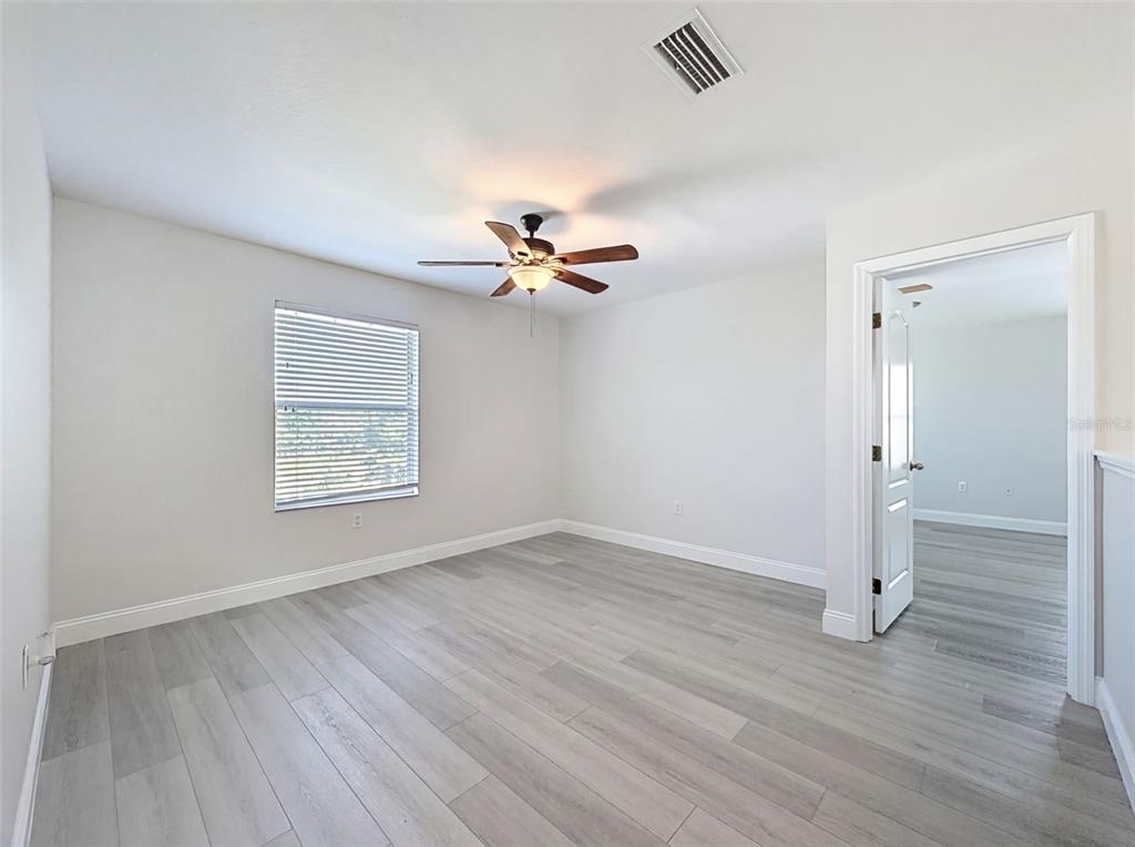 3311 Sisal Loop Wesley Chapel, FL 33544 - Photo 58 of 85 an empty room with wooden floor chandelier fan and windows