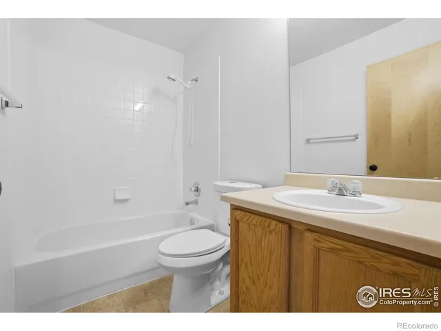 a bathroom with a granite countertop sink toilet mirror vanity and bathtub