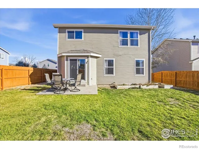 a view of a house with backyard and sitting area