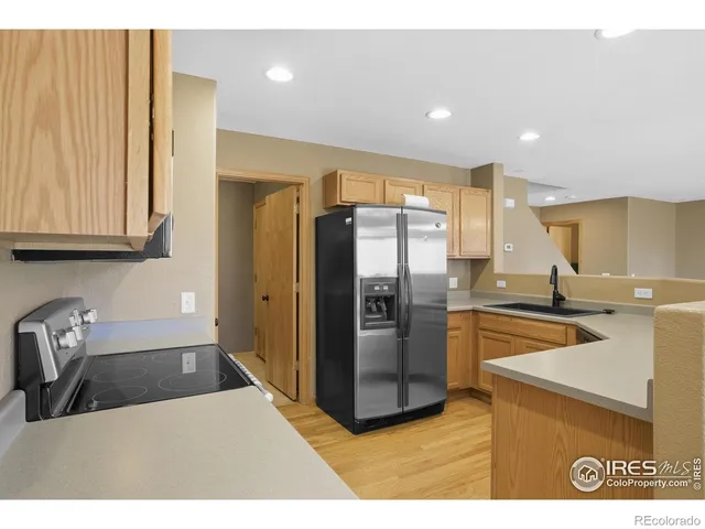 a kitchen with stainless steel appliances granite countertop a refrigerator a sink and a stove
