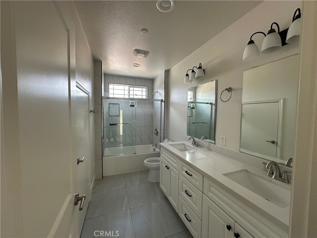 5215 Peony Court Riverside, CA 92506 - Photo 9 of 10 a spacious bathroom with a double vanity sink toilet mirror and bathtub