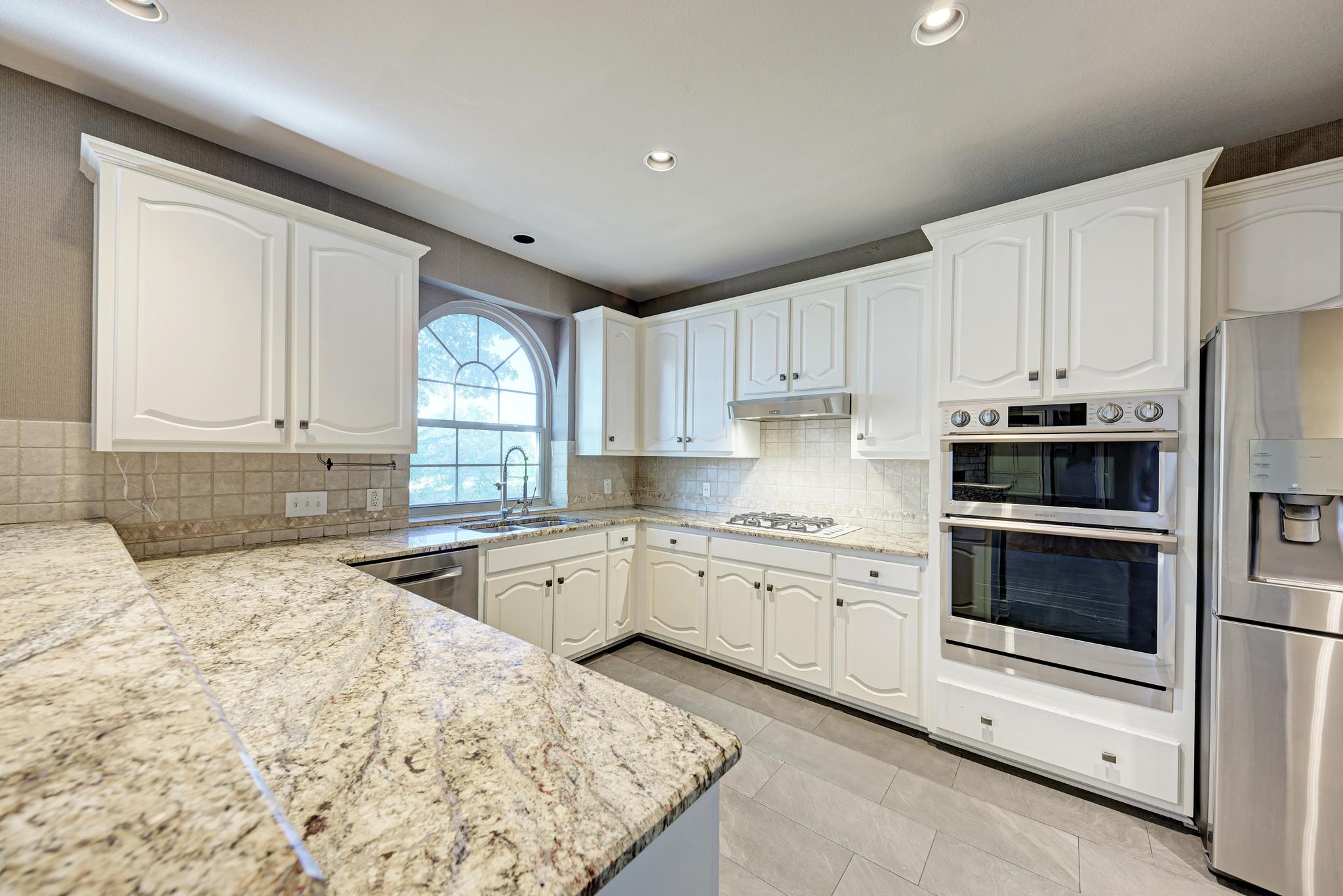 906 Antelope Ridge Cedar Park, TX 78613 - Photo 16 of 40 Polished granite countertops accent classic white cabinetry under soft recessed lighting.