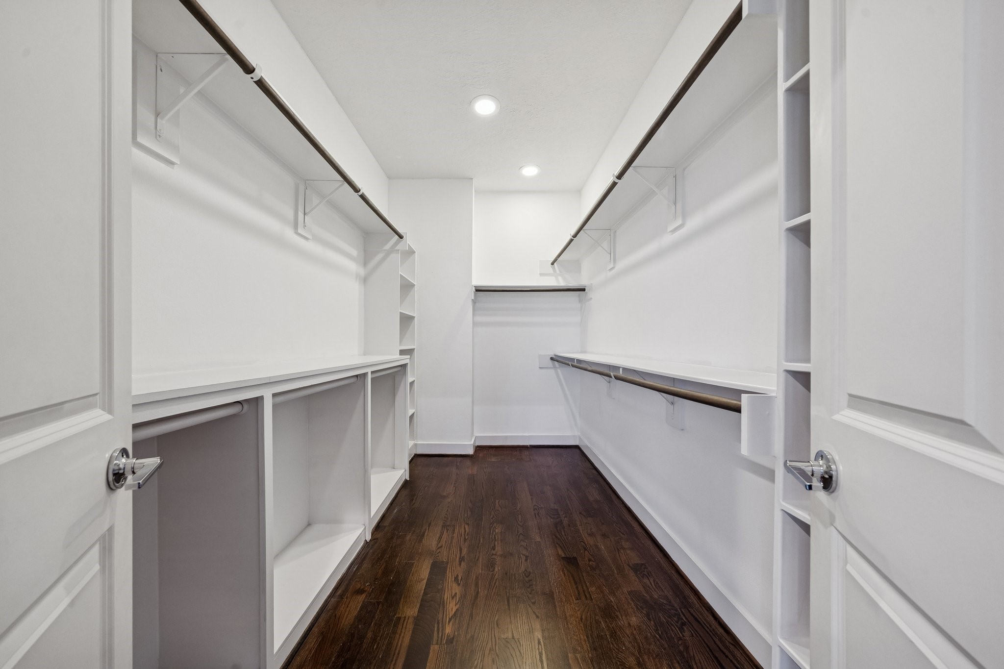 2105 Mason Street Houston, TX 77006 - Photo 13 of 43 The walk-in closet is built out with long hanging rods on both sides and open shelving for shoes, bags, and folded items. Recessed lighting keeps the space bright all the way to the back. It’s a setup that makes staying organized feel straightforward.